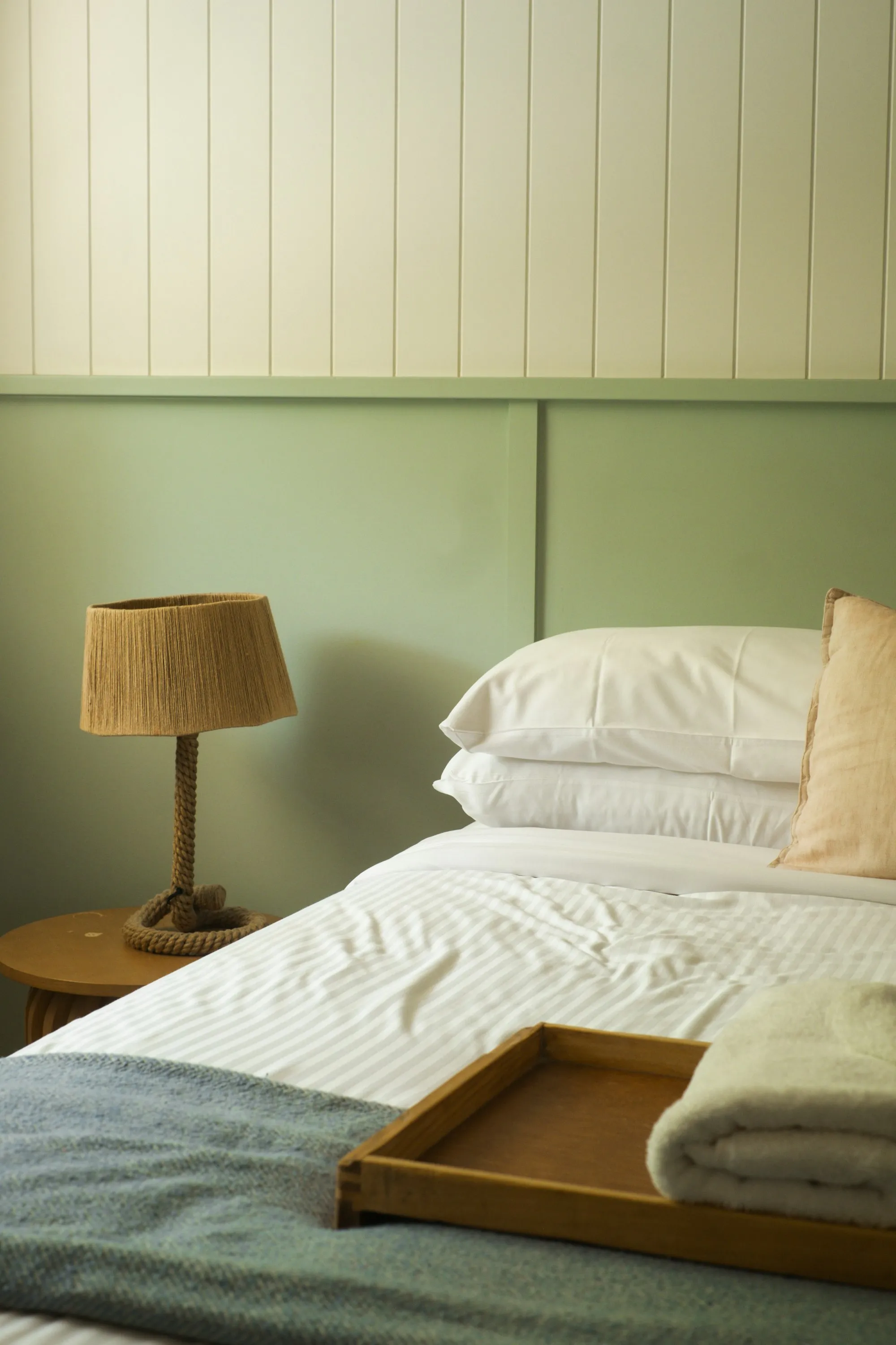Calm coastal main bedroom with a neatly made bed and soft natural light