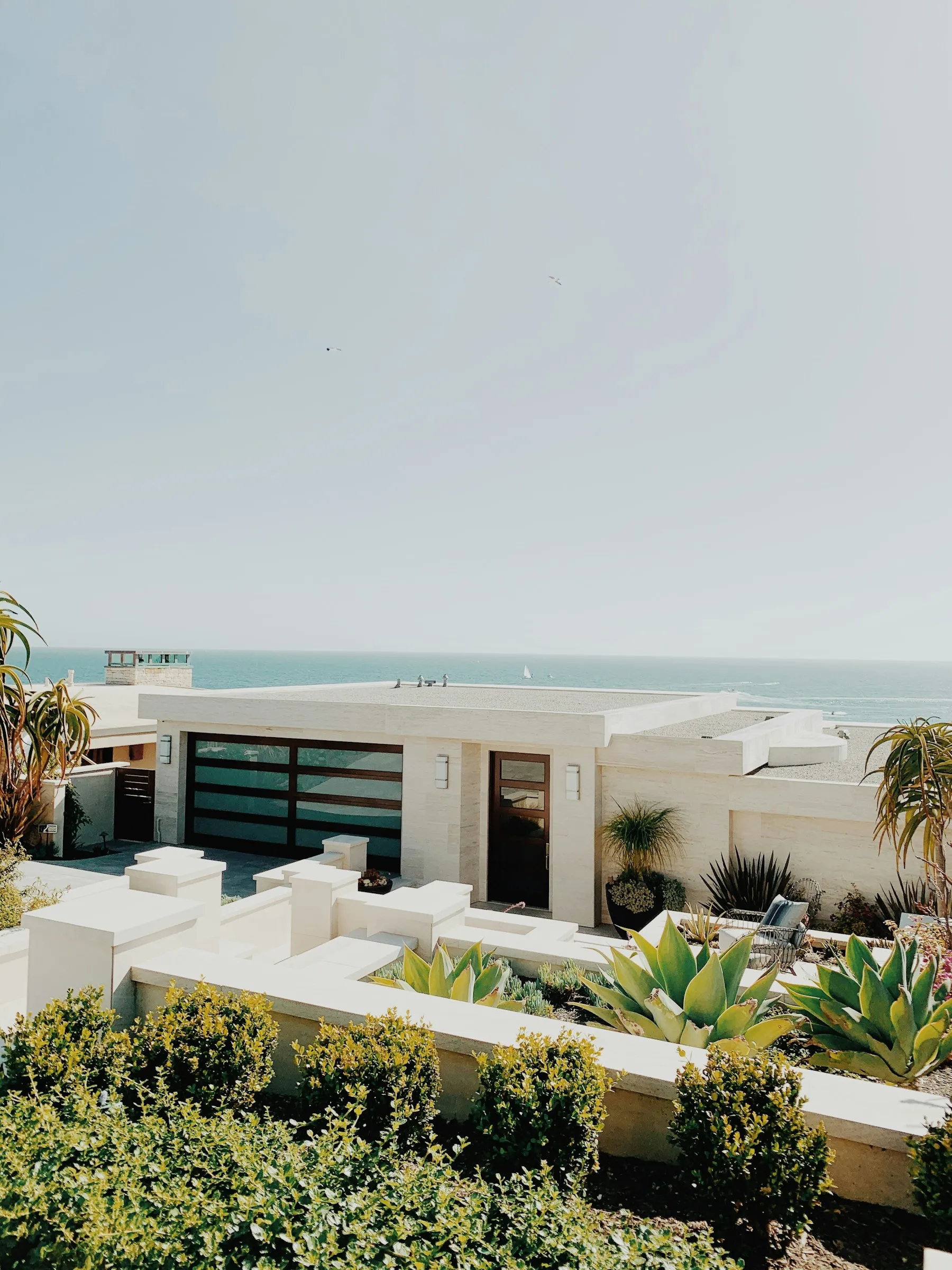 A bright Southern California beach cottage with the Pacific just beyond the succulents and palms