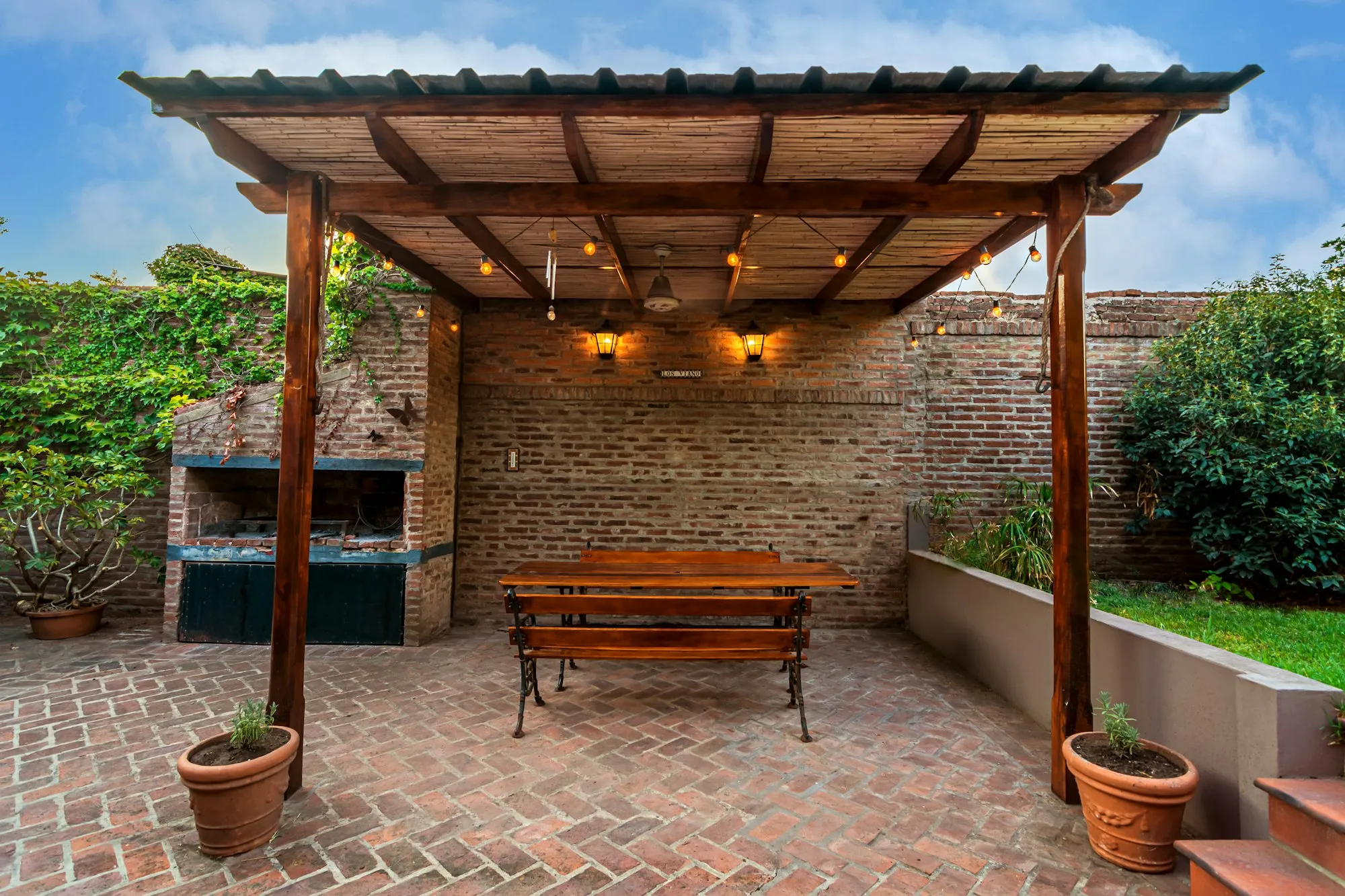 The cottage's private back patio with a pergola and string lights