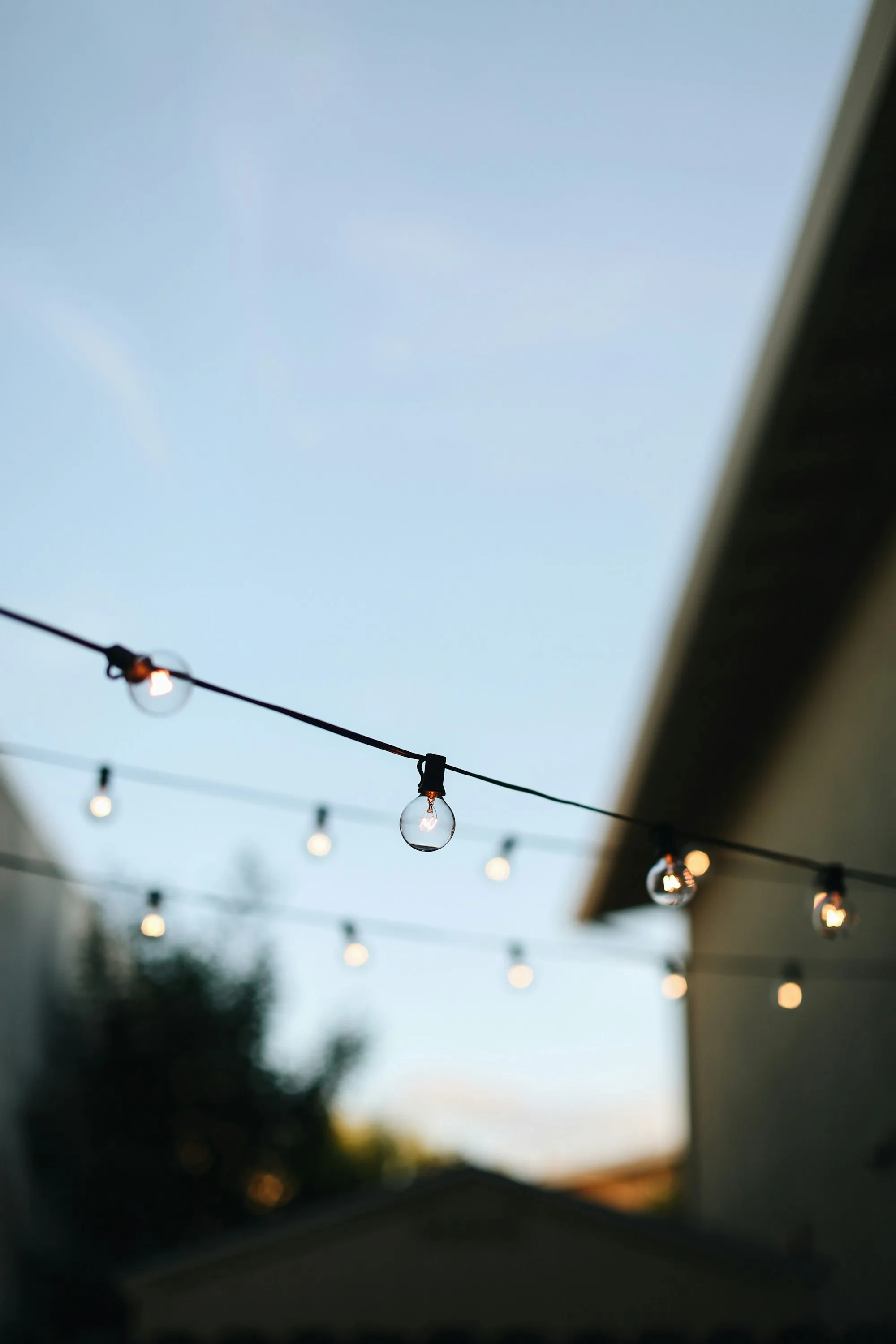 Warm string lights glowing over the patio at dusk
